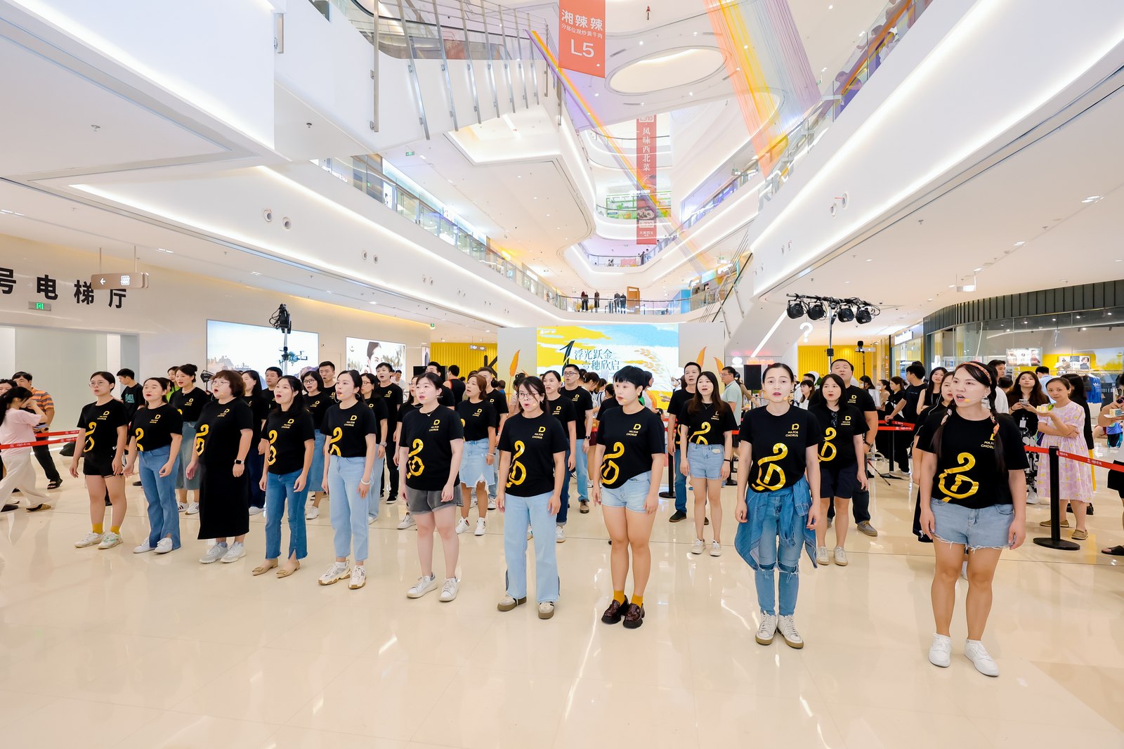 D Major Choir members performing in black choir shirts in a bright shopping mall