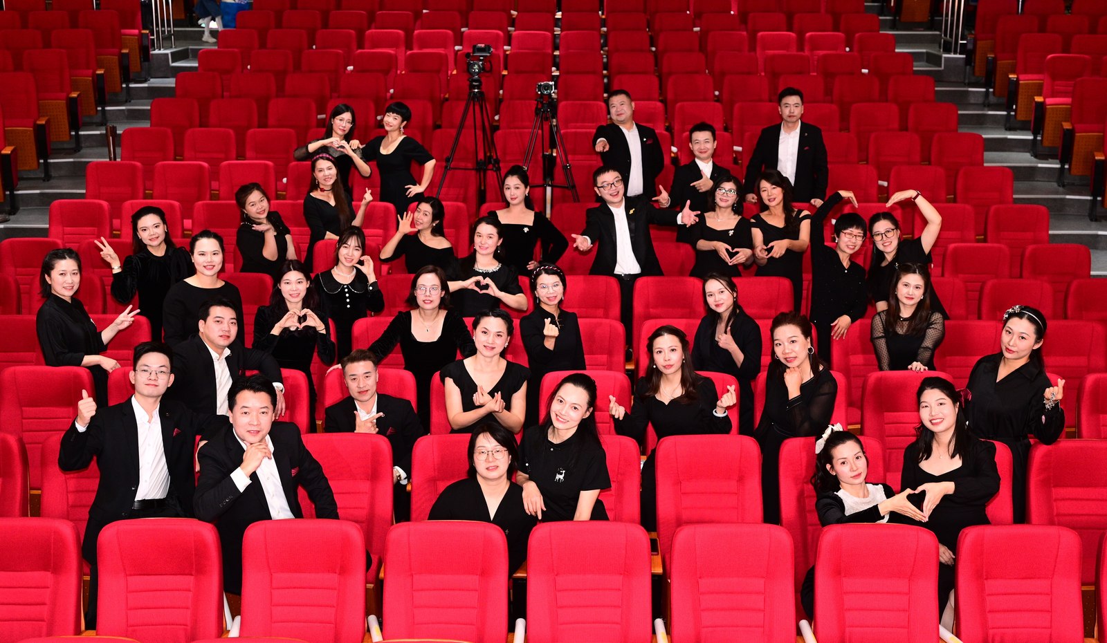 D Major Choir members smiling together among red theatre seats
